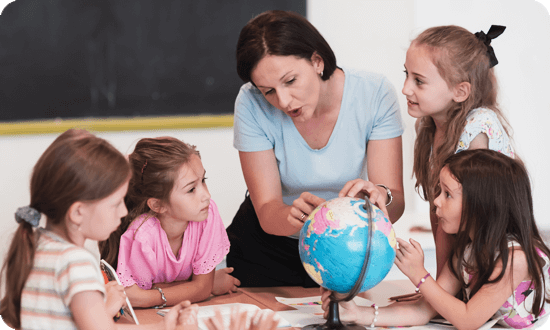 Curious kids examining the Earth globe with their teacher.