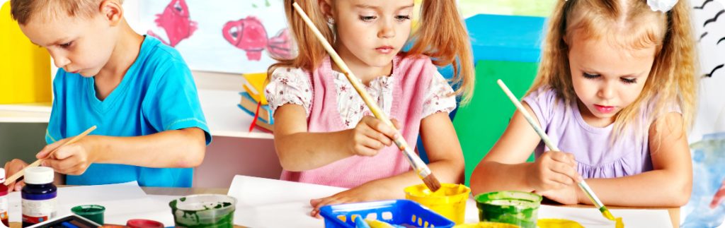 A diverse group of young children engaged in art activities at Wimbledon Day Nursery.