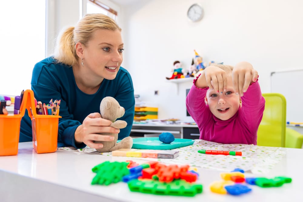 Teacher helps nursery children to develop their cognitive health in wimbledon